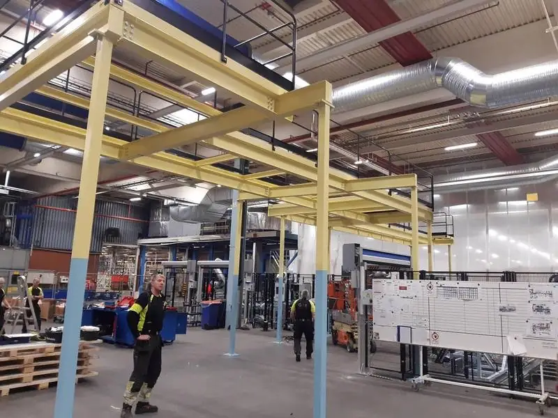 Gul entresolplattform i stål installerad i industrilokal