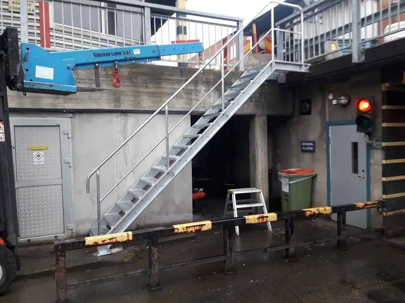 Galvaniserad utetrappa med räcke vid industribyggnad