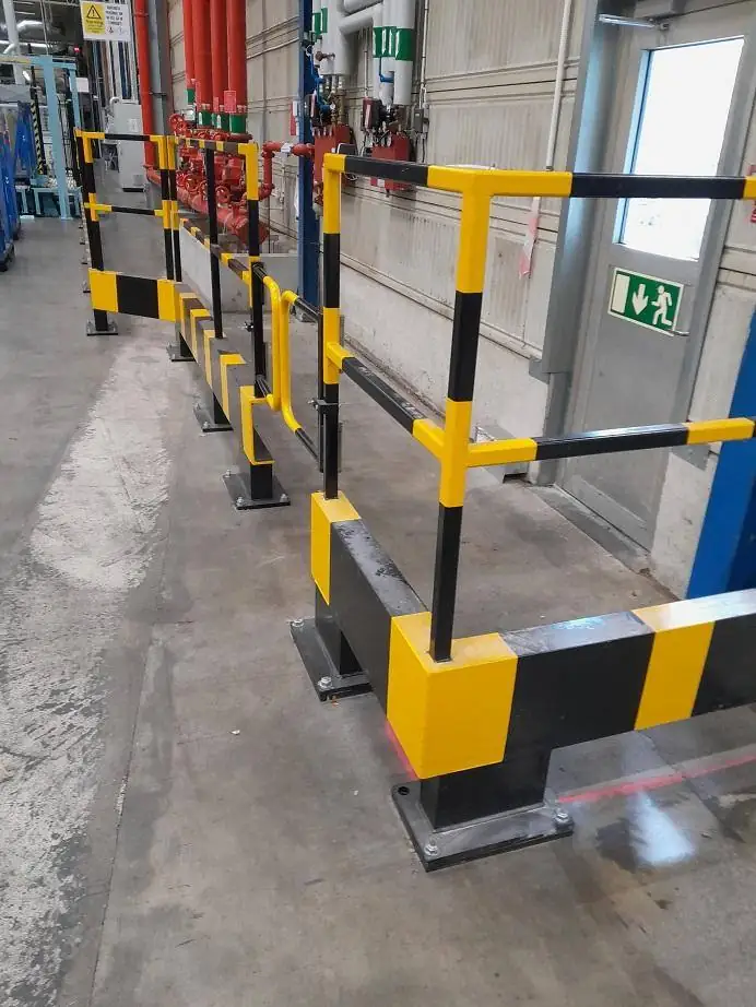Svart- och gulmålade skyddsräcken installerade i industrihall